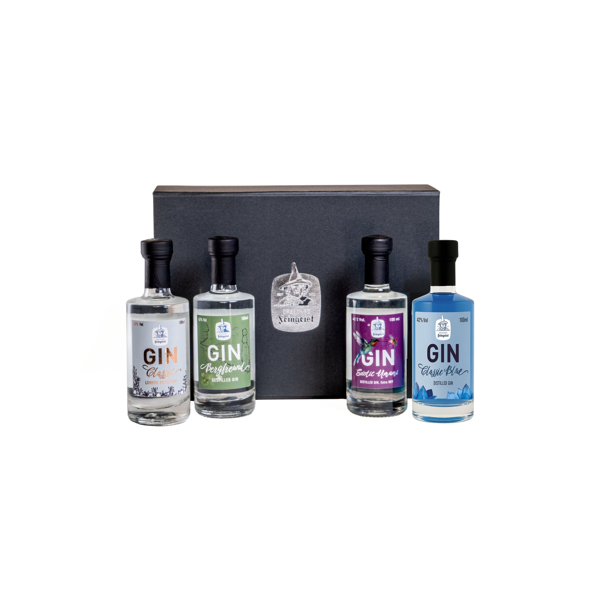 Tastingbox mit vier 100 ml-Flaschen Dresdner Feingeist Gin (Classic, Bergfreund, Exotic Umami und Classic Blue) in schwarzer Geschenkverpackung, vor weißem Hintergrund